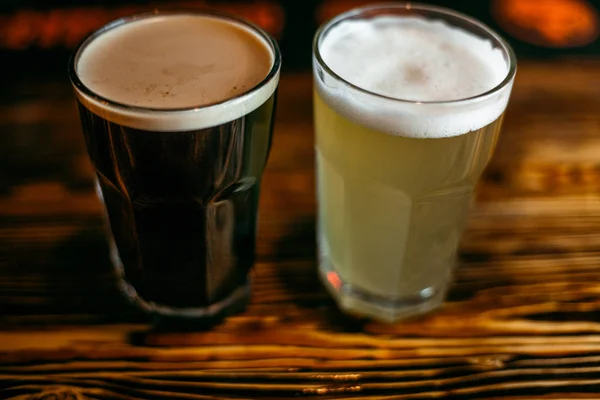 Dark beer. Stout. In a glass grocery. On a wooden table in the bar.