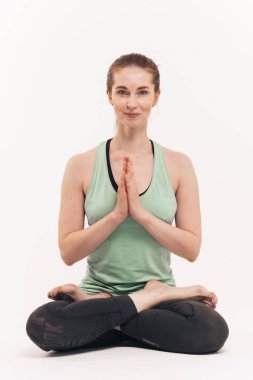 Kız beyaz bir arka plan üzerinde stüdyoda yoga uygulamaları. Nirvana içinde dahil. Nefes yatıştırır. Çakralar bültenleri.
