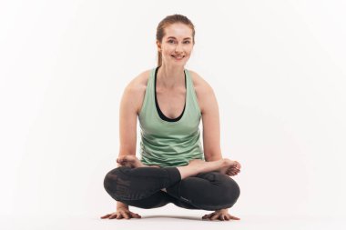 Kız beyaz bir arka plan üzerinde stüdyoda yoga uygulamaları. Nirvana içinde dahil. Nefes yatıştırır. Çakralar bültenleri.