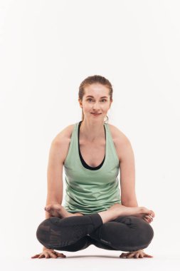 Kız beyaz bir arka plan üzerinde stüdyoda yoga uygulamaları. Nirvana içinde dahil. Nefes yatıştırır. Çakralar bültenleri.