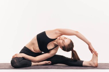 Kız beyaz bir arka plan üzerinde stüdyoda yoga uygulamaları. Nirvana içinde dahil. Nefes yatıştırır. Çakralar bültenleri.