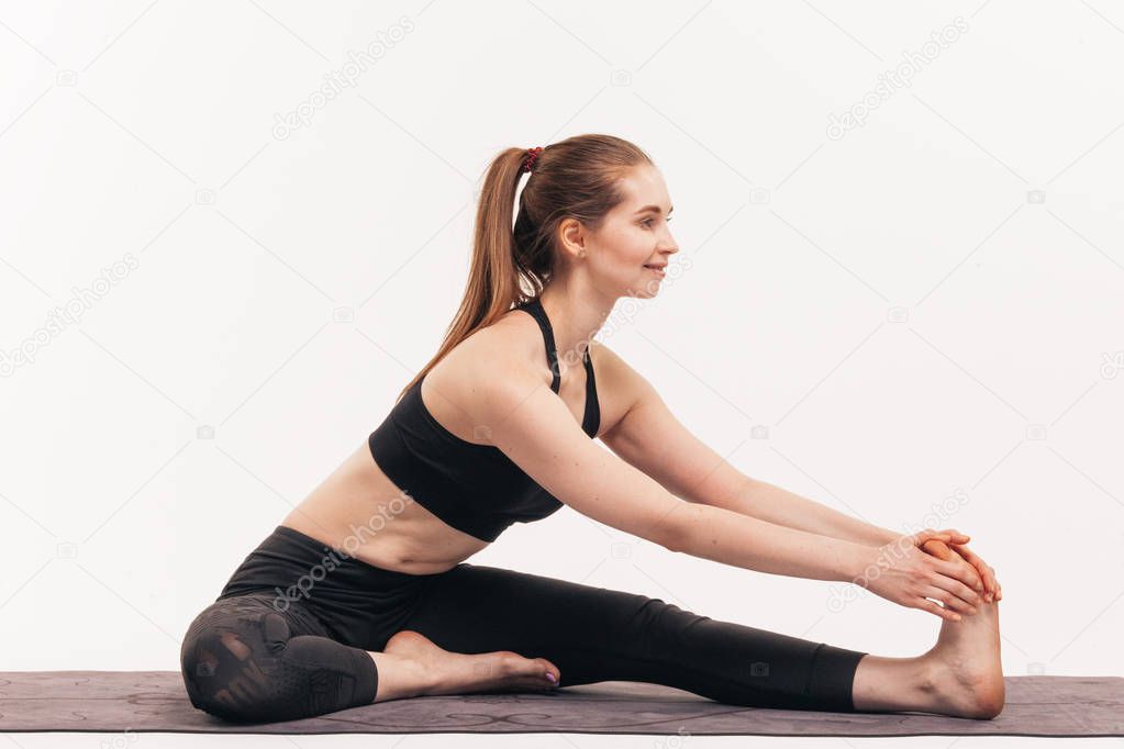 The girl practices yoga in the studio on a white background. Included in nirvana. Soothes breathing. Releases the chakras.
