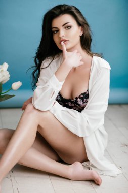 moda portre sevimli genç esmer kadın iç çamaşırı mavi duvar arka plan üzerinde poz