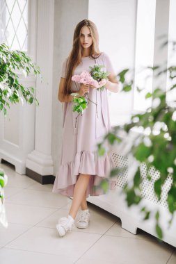 kameraya bakarak moda pembe elbisenin içinde poz şirin sarışın genç kadın