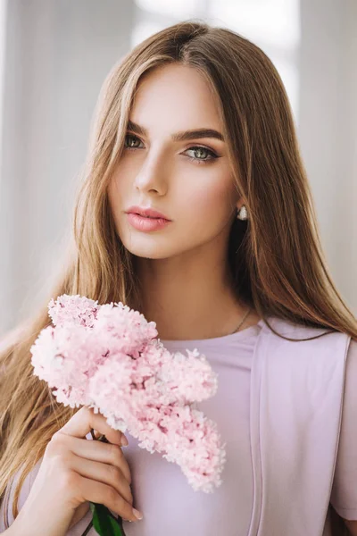 kameraya bakarak pembe çiçekler ile poz çekici sarışın genç kadın moda portre