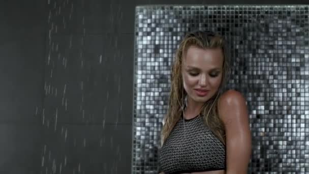 濡れた髪と美しいセクシーなブロンドの女の子 水の低下の下でシャワーで水着でポーズ スローモーション — ストック動画