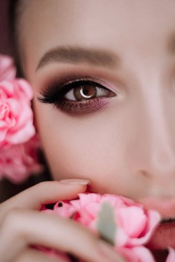 güzel bir kız makyaj ve çiçekler güzellik portresi. Studio pembe bir arka plan üzerinde makro çekim