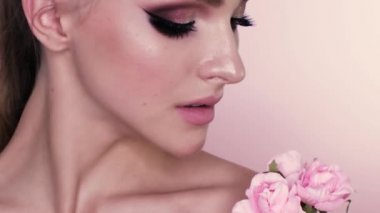 güzel bir kız makyaj ve çiçekler güzellik portresi. Studio pembe bir arka plan üzerinde makro çekim