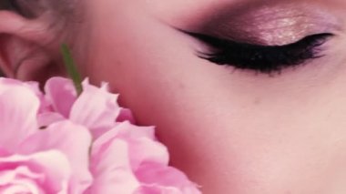 güzel bir kız makyaj ve çiçekler güzellik portresi. Studio pembe bir arka plan üzerinde makro çekim