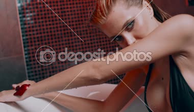 güzel seksi genç sarışın kadını banyo gül yaprakları ile