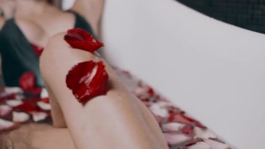 güzel seksi genç sarışın kadını banyo gül yaprakları ile