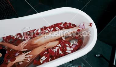 güzel seksi genç sarışın kadını banyo gül yaprakları ile