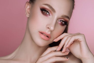 makyaj ve saç kesimi pembe bir arka plan üzerinde Studio ile güzel bir zarif esmer kız portresi
