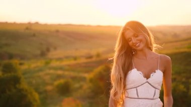 Beyaz elbise güzel seksi sarışın kız meyve sepeti ile günbatımı bir alanda poz 