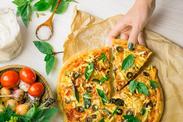 Hands taking slices of pizza. Hand holding slice pizza. Hand taking pizza slices from white wooden background