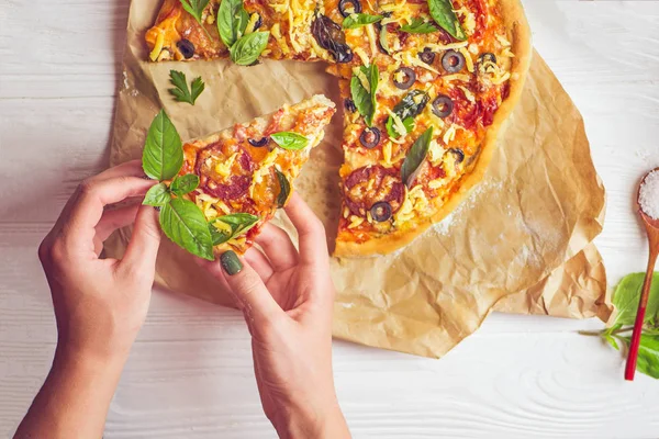 Hands taking slices of pizza. Hand holding slice pizza. Hand taking pizza slices from white wooden background