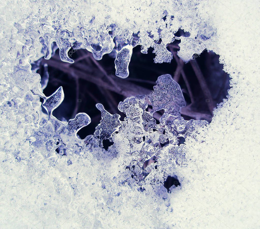 Snow texture melts on dry grass. Texture of white snowin the shape of the heart. Winter background with melts snow drifts in the shape of the heart