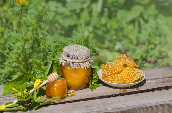 蜂蜜の瓶、花の背景を持つ木製のテーブルの蜂のハニカム — ストック写真