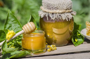 Rustik ahşap masa arka plan üzerinde bal dipper ile kavanozda Bal