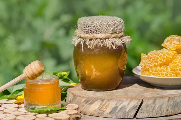 Rustik ahşap masa arka plan üzerinde bal dipper ile kavanozda Bal