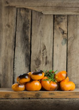 Kırsal ahşap arka planda olgun domatesler. Renkli domates Alice Masada Hayal Et.
