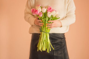 Beyaz elbiseli, genç ve güzel bir kız. Renkli, taze çiçekli lale.