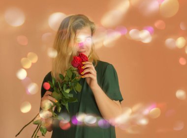 Kırmızı güllerle süslenmiş neşeli genç bir kızın portresi