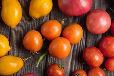 Masada kırmızı domates var. Tahta masada bir sürü domates var. Tahta masadaki taze organik domatesler.