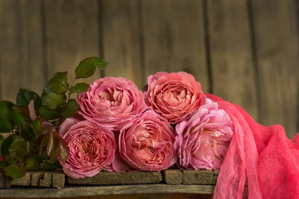 Colorful flowers on a table. Beautiful flowers on wooden table. Pink rose background