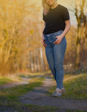 Bahar ormanlarında yürüyen bir kadın. Bahar parkında yürüyorum. Bahar ormanlarında yürüyen güzel genç bir kadın.