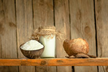 Hindistancevizi yağı ve taze hindistan cevizi gevreği. Cam kase hindistan cevizi talaşı..