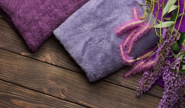 Ahşap arka planda banyo havluları. Mavi ve mor banyo havlusu
