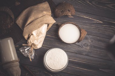 Hindistan cevizi sütü ve taze hindistan cevizi gevreği. Cam kase hindistan cevizi talaşı. Camda rendelenmiş hindistan cevizi