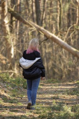 Bahar ormanlarında yürüyen bir kadın. Bahar parkında yürüyorum. Bahar ormanlarında yürüyen güzel genç bir kadın.
