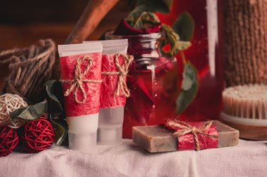 Vücut bakımı için plastik şişelerle kompozisyon. Gül yağlı kırmızı kozmetik. Kırmızı spa seti.