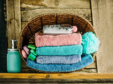 Bir yığın havlu, sabun, bez, jöle. Ahşap arka planda banyo havluları yığını