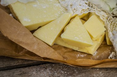 Dantelli ve beyaz çiçekli kakao yağı parçaları. Kahverengi kağıtta beyaz çikolata.