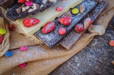 Çikolata karışımı fındıklı ve kurutulmuş meyveler kırsal ahşap arka planda. Çikolata pişirme süreci. 