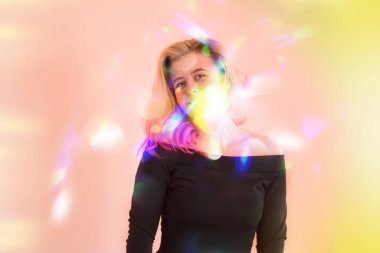 Renkli parlak ışık altında poz veren bir kadın. Gülümseyen mutlu bir kadın. Gençlik ve mutluluk kavramı.