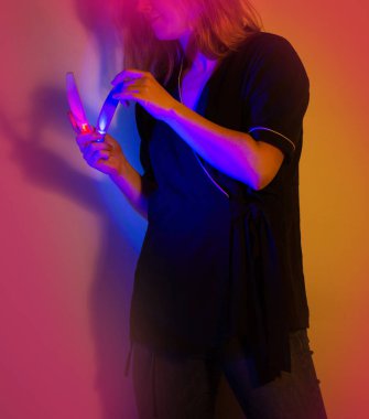 Attractive nail salon worker in working form on bright vivid neon energetic multicolor background. Profession of nail service master is a modern trendy vision.