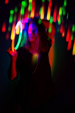 Sahnede dans eden genç ve güzel bir kadının portresi neon renkli parlak bir gradyan..