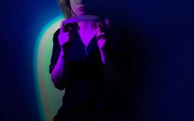 Positive female model with colorful bright neon glowing backdrop. Happy stylish woman professional nail service master on bright neon background