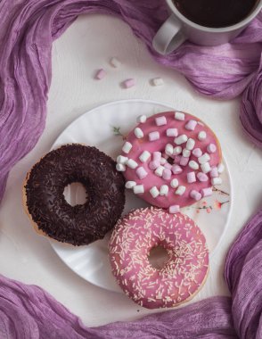 Renkli şekerli çörekler ve beyaz arka planda çay fincanı. Tatlı ve fırın konsepti.