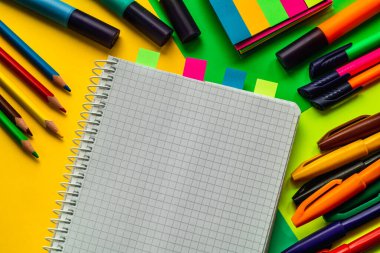 Renkli okul malzemeleri ve renkli bir arka planda bir defter. Okul kavramı.