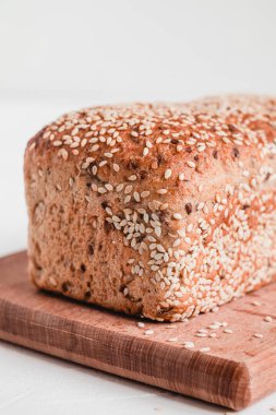 Taze susamlı ekmek beyaz bir arka planda tahta bir tahta üzerinde.
