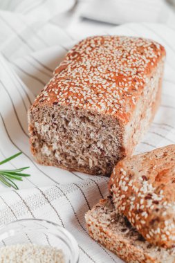 Biberiyeli açık masa örtüsü üzerinde susamlı dilimlenmiş ekmek..