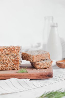 Taze susamlı ekmek ve sütle kahvaltı. Tahtada tam tahıllı ekmek. Glütensiz ekmek. Boşluğu kopyala.