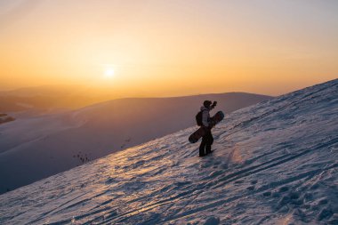 gün batımı sırasında karlı tepenin üzerinde duran kar yatılı silüeti
