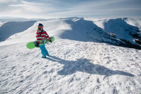 gündüz tepenin üzerinde duran kadın kar-Boarder arka görünümü