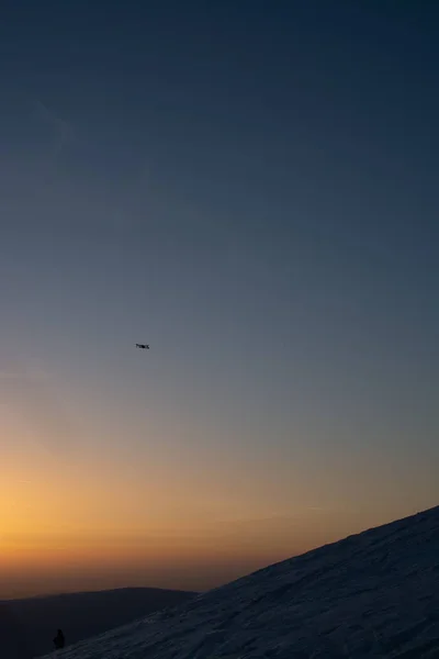 drone gün batımı arka planda kar kaplı tepeler üzerinde uçan 